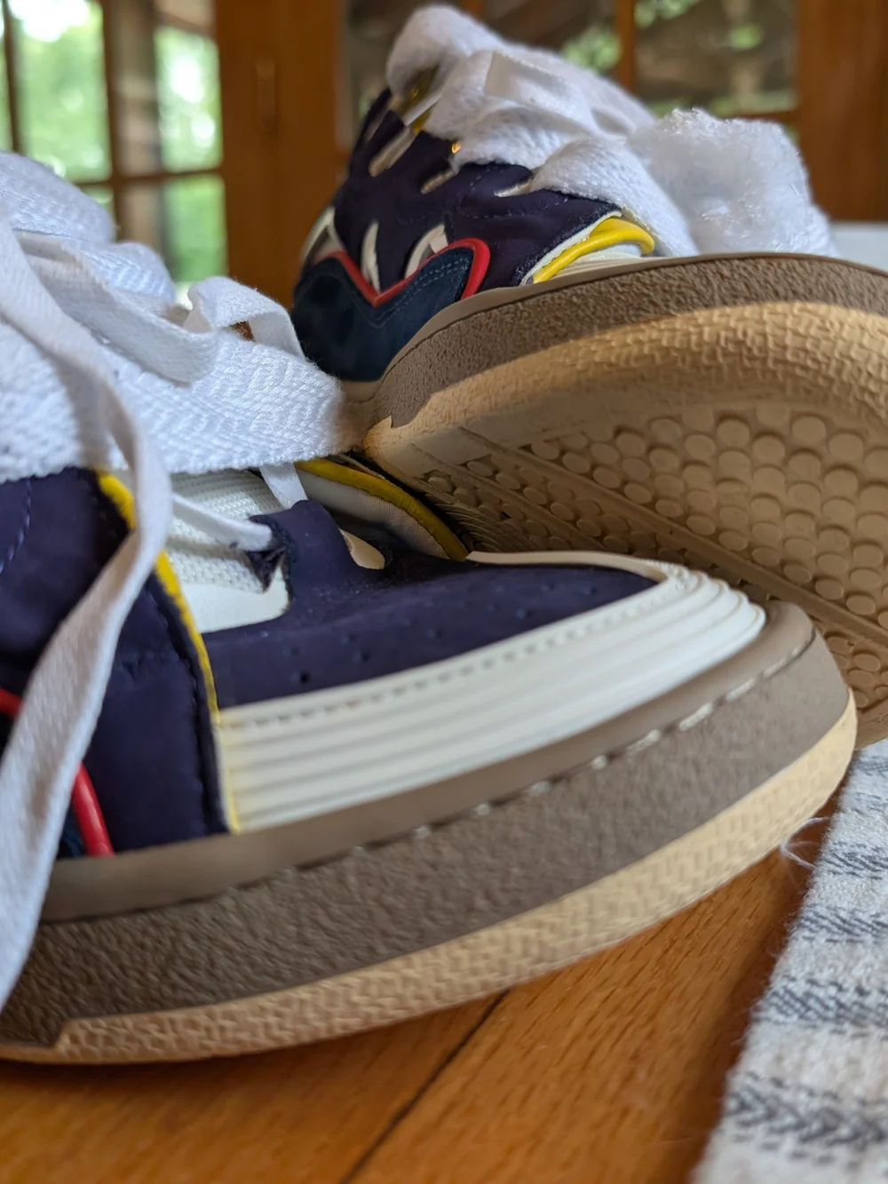 Lanvin Curb Sneakers in a distinct Navy Blue, White, Red, and Yellow colorway.